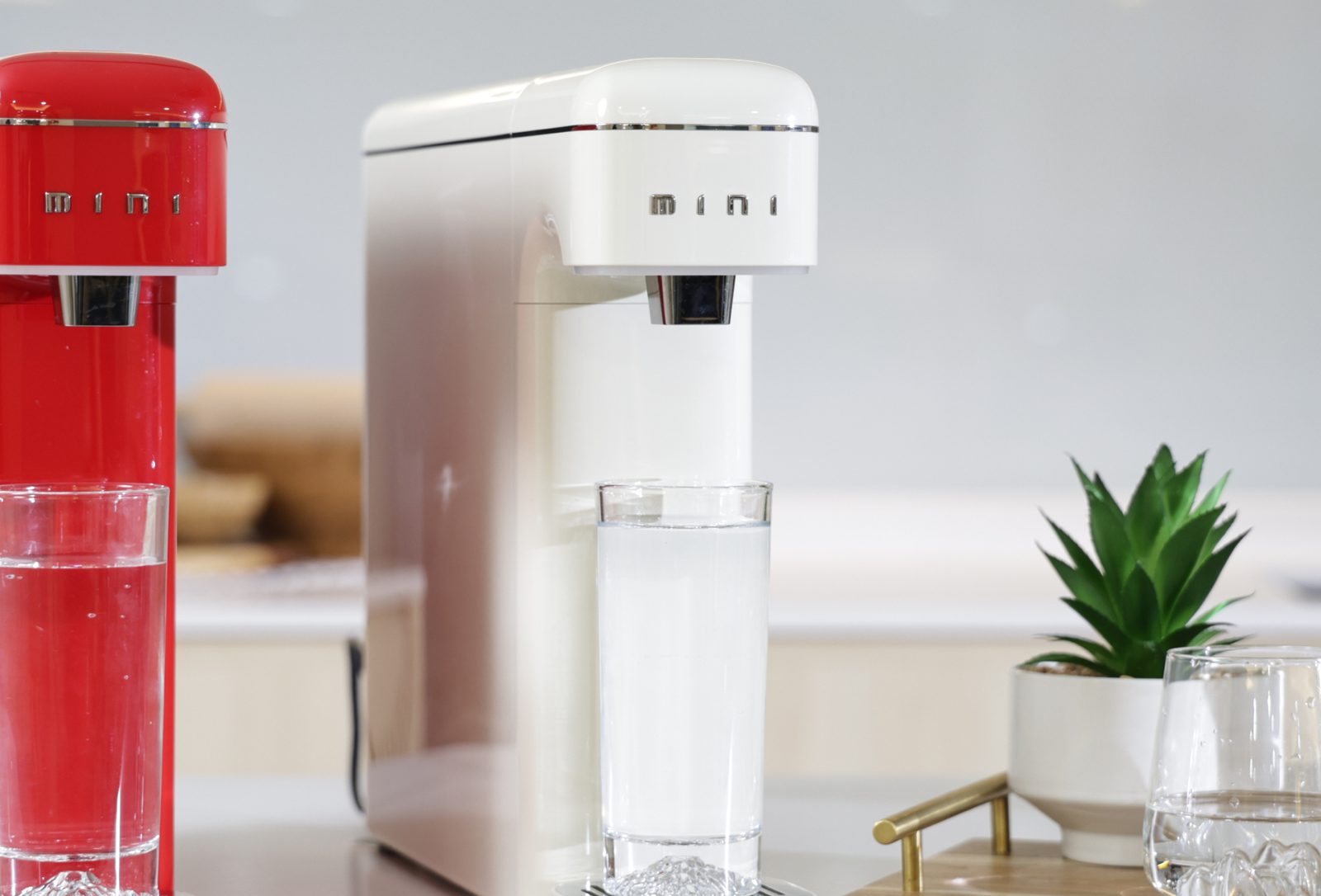 SK Magic JIKSOO Mini water purifier in Red and Cream on a kitchen counter, dispensing a glass of water